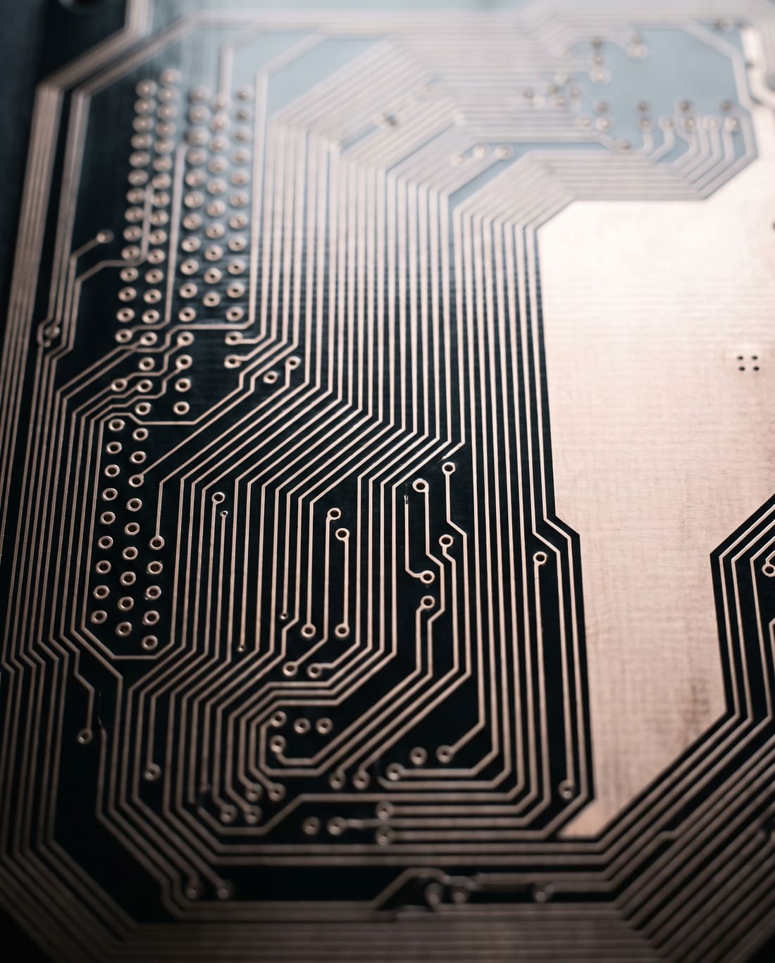 Macro of a bare circuit board, copper traces reading like a city plan