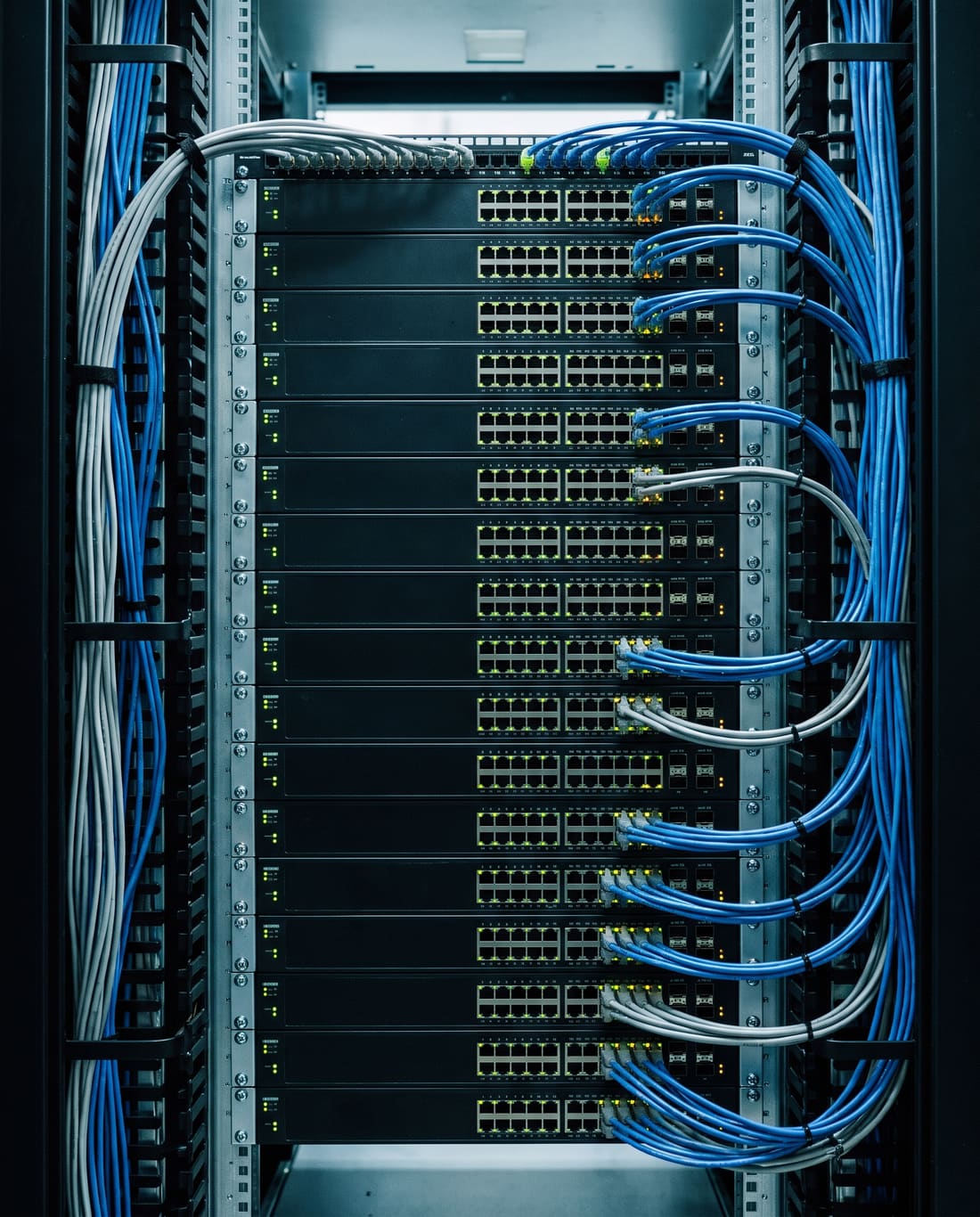 A network rack front-on, switches stacked in alignment with dressed cabling